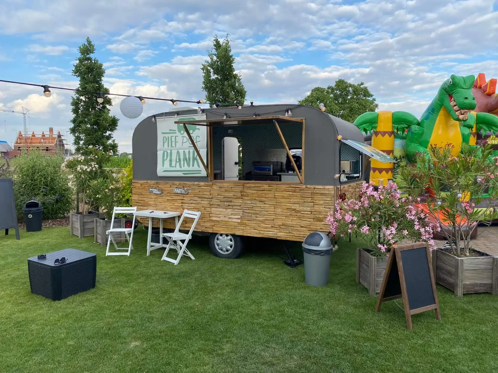 De zelfgebouwde Pief Pof Plank-foodtruck op een tuinfeest, met houten latten en open serveerluik