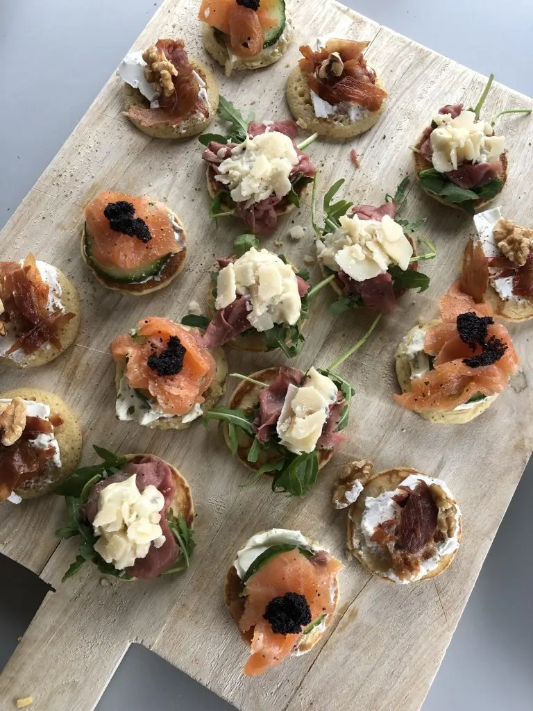 Blini's met gerookte zalm op een houten serveerplank