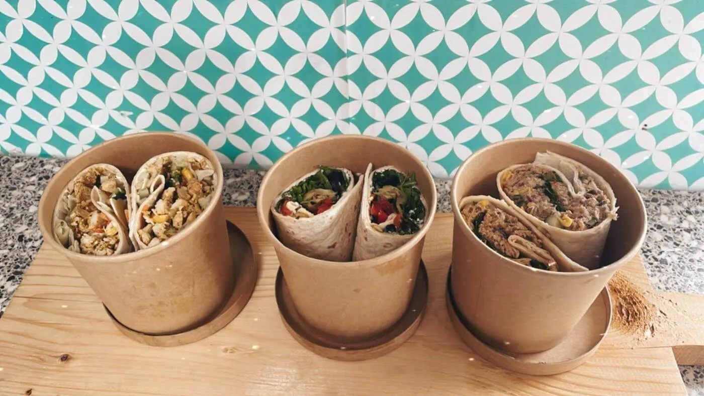 Wraps in bakjes op een tafel met retro behang